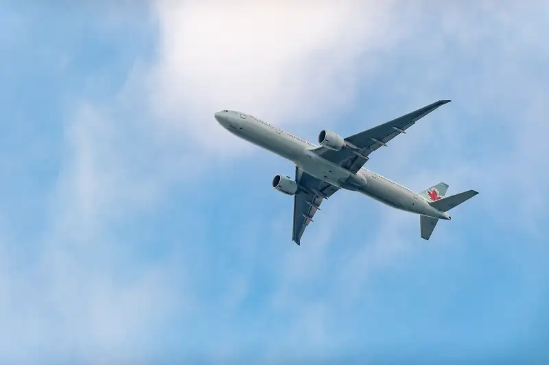 Air Canada Airplane in the distance flying in blue skies,