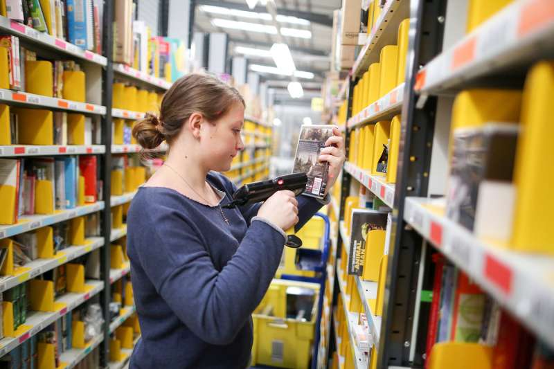 An employee selects an item for distribution at the Amazon.com Inc. fulfillment center in Hemel Hempstead, U.K., on November 25, 2015.