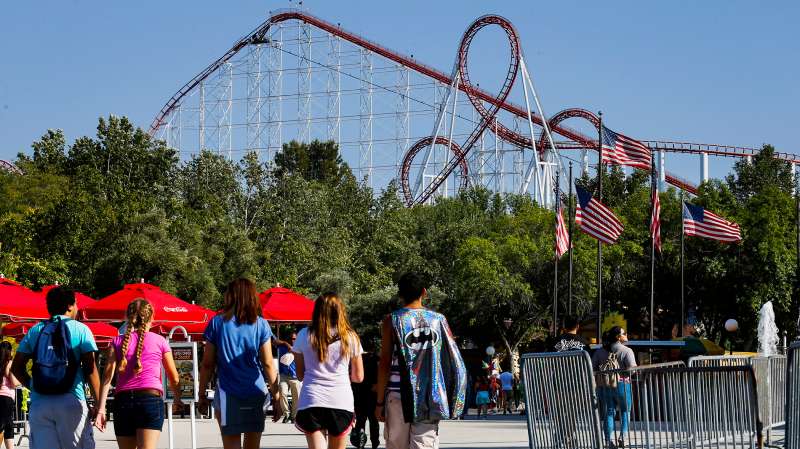 Visitors walk towards a roller coaster at Six Flags Magic Mountain in Valencia, California, on April 20, 2015.