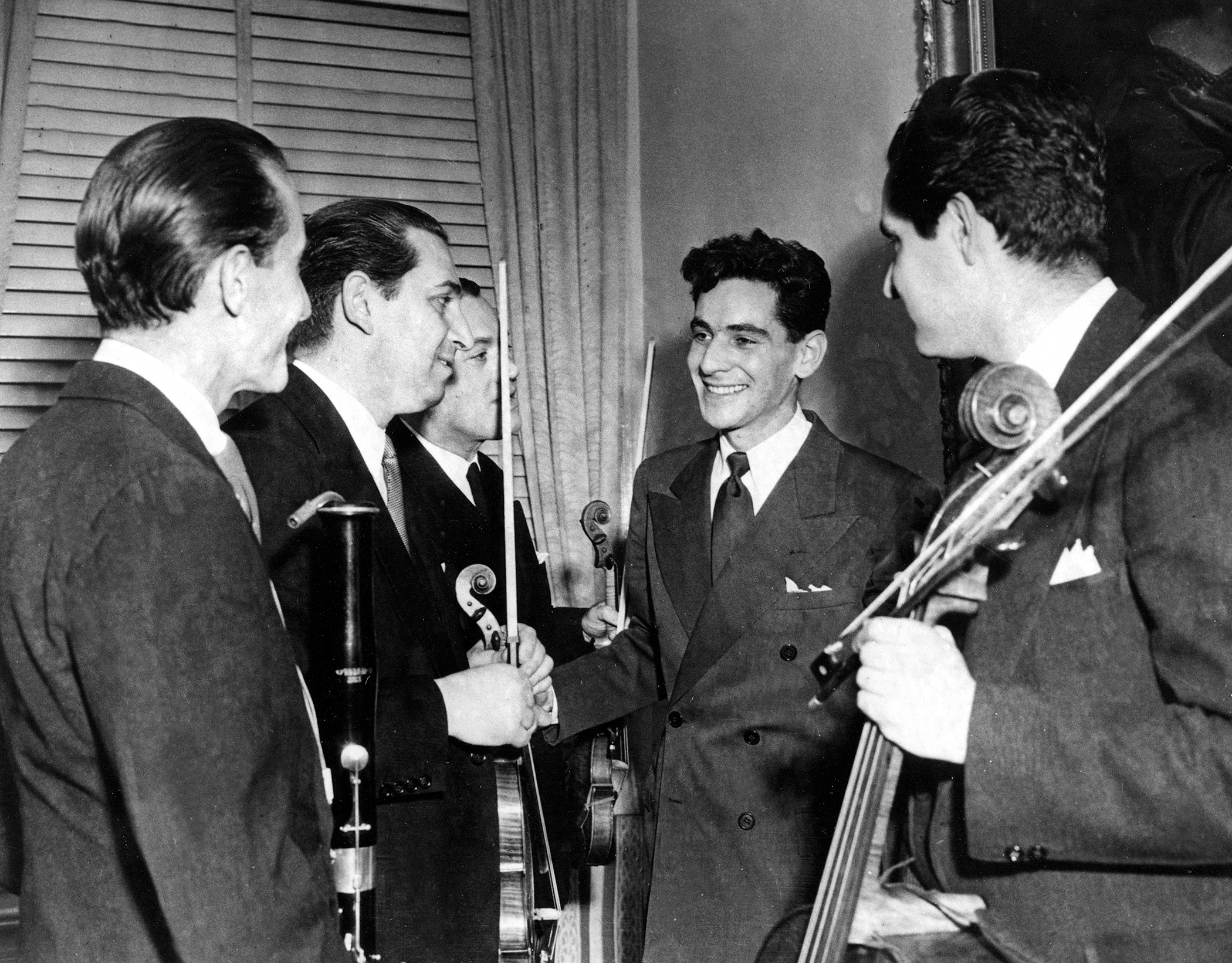 Leonard Bernstein, second from right, Assistant Conductor of the New York Philharmonic-Symphony Orchestra, is congratulated by members of the orchestra after the 25-year-old musician made his debut at Carnegie Hall in New York, Nov. 14, 1943. Bernstein substituted for Bruno Walter, who had become ill, to lead the organization in a 90-minute national radio broadcast.