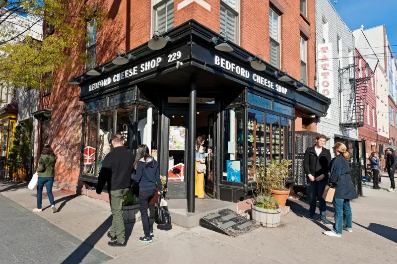 A cheese shop is a gathering point for people on Bedford Avenue in the Williamsburg neighborhood in Brooklyn, New York City, 2013.