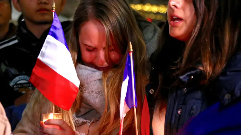 Members of the Australian French community cry as they sing the French national anthem during a vigil in central Sydney, Australia, on July 15, 2016, to remember the victims of the Bastille Day truck attack in Nice.