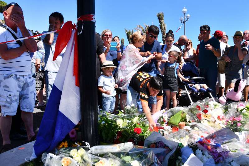 People visit the scene and lay tributes to the victims of a terror attack on the Promenade des Anglais on July 15, 2016 in Nice, France. A French-Tunisian attacker killed 84 people as he drove a lorry through crowds that were gathered to watch a firework display during Bastille Day celebrations.