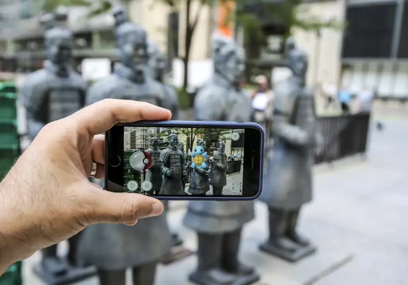 People take photo of the Terra Cotta warriors replicas in Chicago, United States on July 14, 016 as Pokemon go game is seen on a screen of a phone. Chicago Field Museum has created its own treasure hunt game while many are obsessed with Pokemon game. The museum began giving out clues on social media about the spots in Chicago to see life-size replicas of the terra cotta statues. The treasure hunt is a promotion for the Field Museum's special exhibit China's First Emperor and His Terracotta Warriors, where some of the original terra cotta figures and two painted replicas are on display.