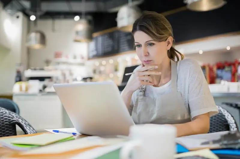 Woman using a laptop inside a small coffee shop