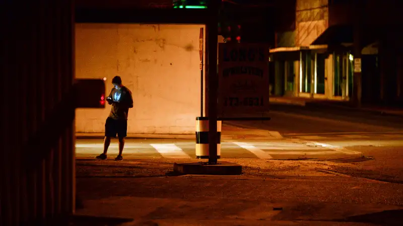 A teenagers plays  Pokemon Go  in downtown Hartselle, Alabama, at night on July 13, 2016.