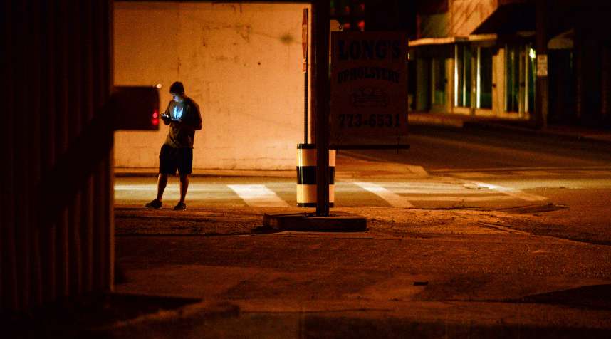 A teenagers plays  Pokemon Go  in downtown Hartselle, Alabama, at night on  July 13, 2016.