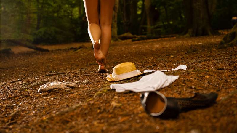 person leaving clothes behind to run into woods