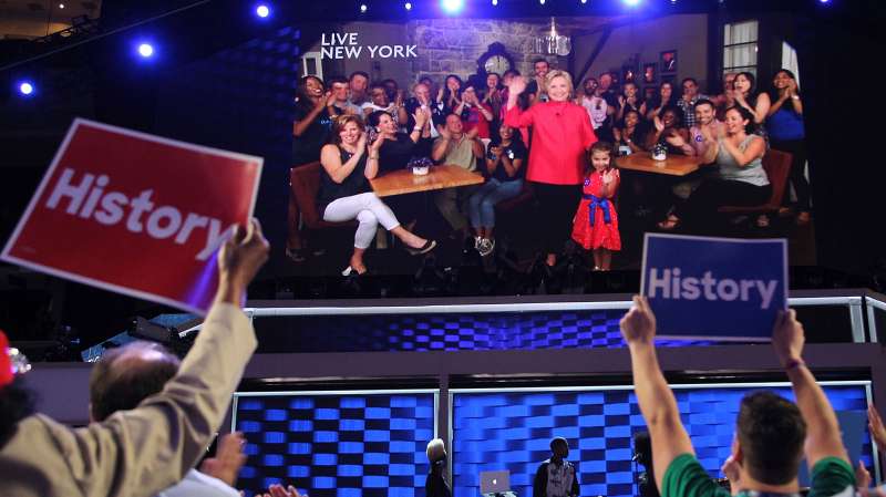 Democratic presidential nominee Hillary Clinton delivers remarks via a video screen on the second day of the 2016 Democratic National Convention at Wells Fargo Center on July 26, 2016 in Philadelphia, Pennsylvania.