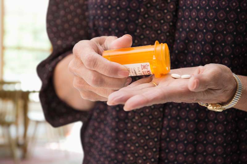 Mixed race woman holding medication pills