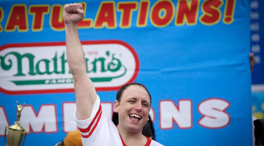 NEW YORK, NY - JULY 04: Joey Chestnut celebrates after winning the 98th annual Nathan's Famous Hot Dog Eating Contest at Coney Island on July 4, 2014 in the Brooklyn borough of New York City.  Chesnut won his eighth straight Nathan's Hot Dog Eating Contest with 61 hot dogs. (Photo by Kena Betancur/Getty Images)