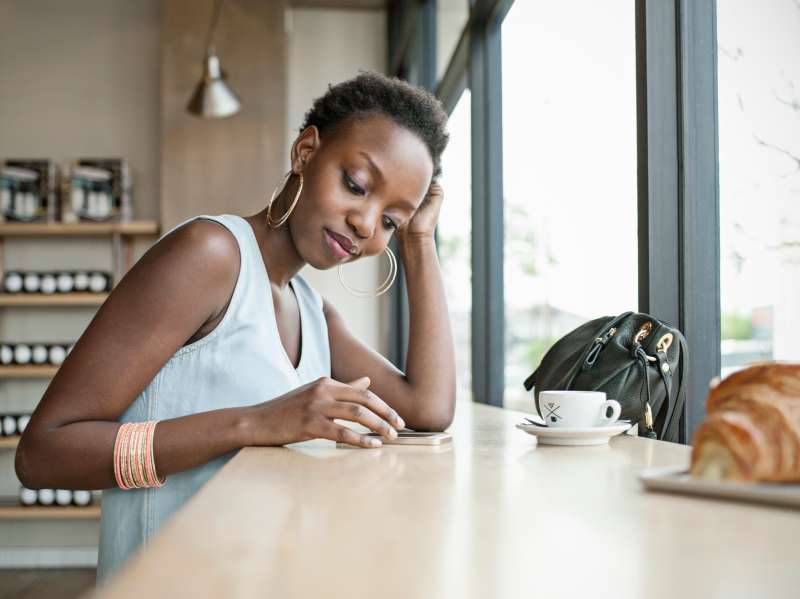 Young woman in café with mobile phone