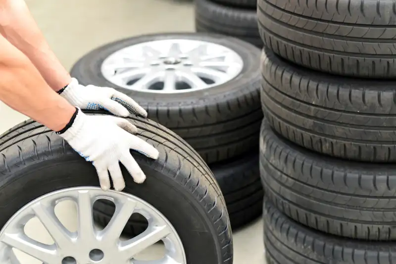 Close-up of car mechanic with tires