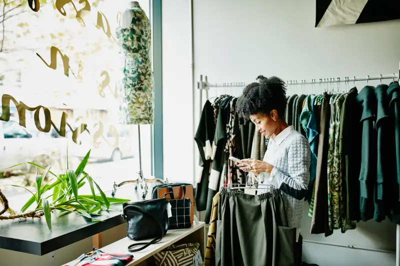 Woman checking smartphone while shopping