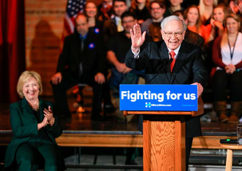 Democratic presidential candidate Hillary Clinton listens as billionaire investor Warren Buffett speaks at a Clinton Grassroots Organizing Event in Omaha, Nebraska, Dec. 16, 2015.