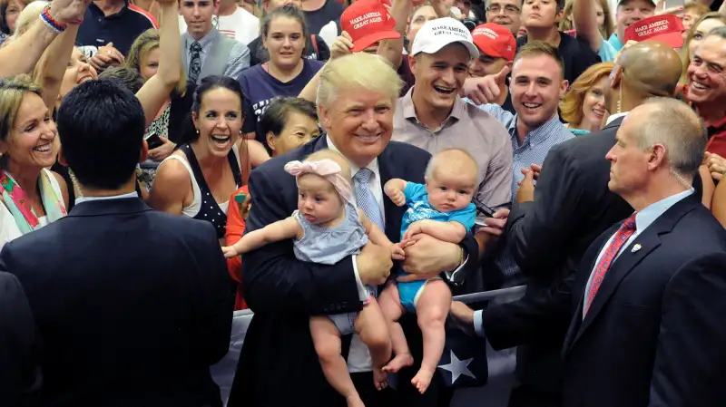 US Republican Presidential Candidate Donald Trump holds two babies after his Town Hall address at the Gallogly Events Center in Colorado Springs, Colorado, on July 29, 2016.