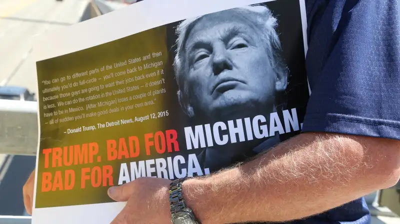 As Republican presidential candidate Donald Trump speaks inside to a business crowd at the Detroit Economic Club at Cobo Center, a protestor holds a sign showing his perspective Aug. 8, 2016 in downtown Detroit, Mich.