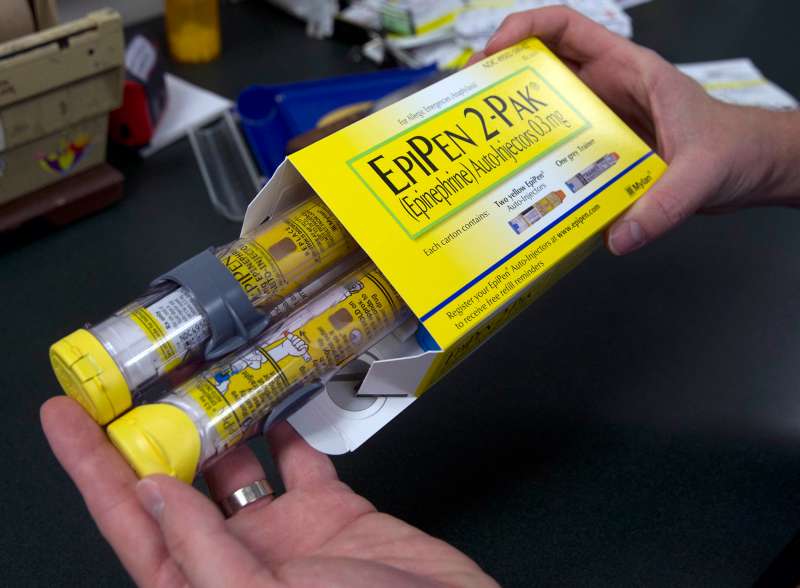 A pharmacist holds a package of EpiPens epinephrine auto-injector, a Mylan product, in Sacramento, Calif. Mylan said it will make available a generic version of its EpiPen, as criticism mounts over the price of its injectable medicine.