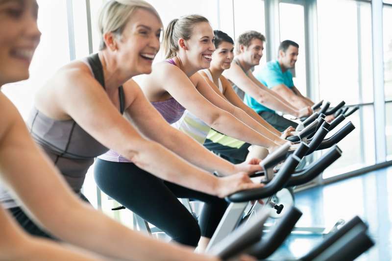 People exercising on stationary bikes in fitness class