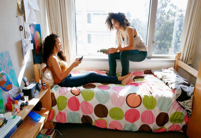 Mixed race college students relaxing in dorm