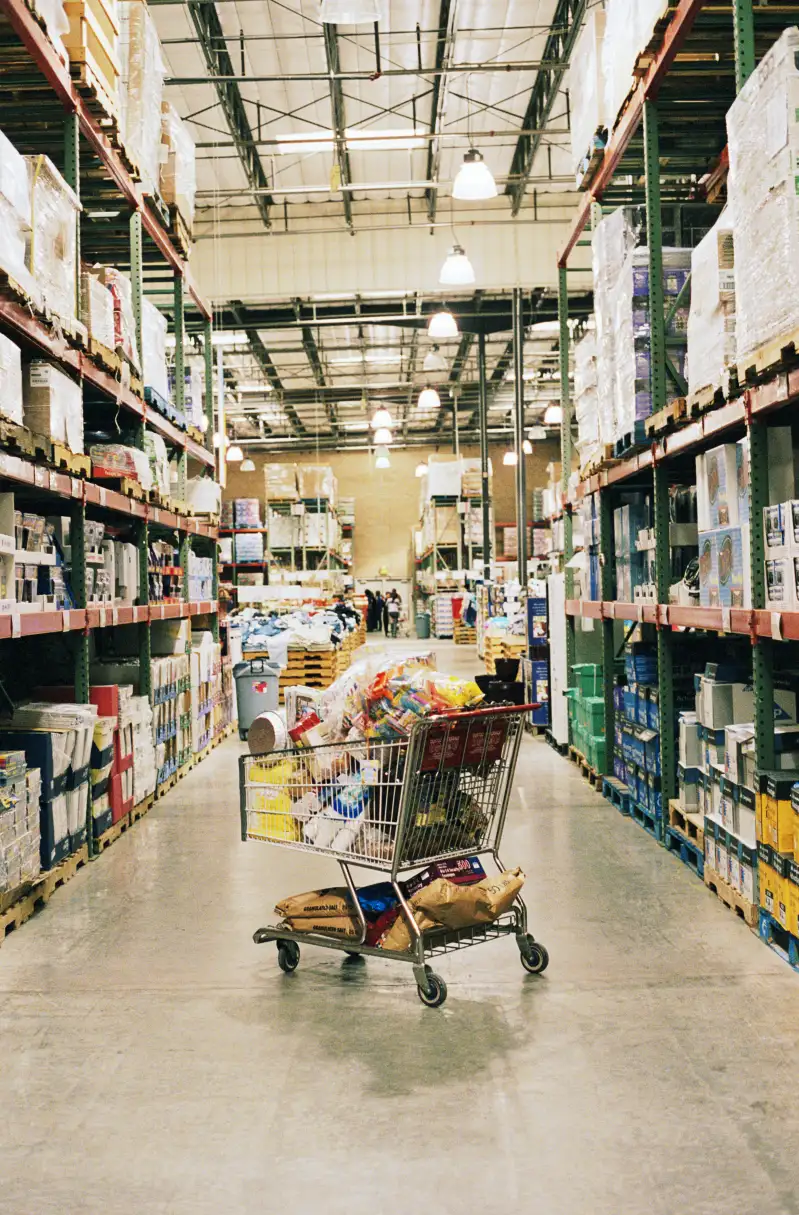 Shopping cart full of groceries in discount warehouse store