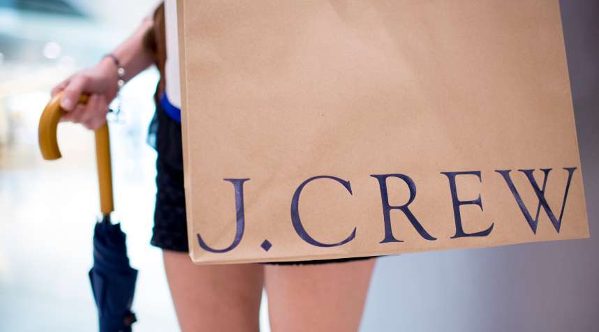 A woman poses for a photograph with a bag outside of J. Crew Group Inc.'s new women's store inside the International Finance Centre (IFC) mall in Hong Kong, China, on Thursday, May 22, 2014. J. Crew, the retail chain that opened its first Asian stores today, plans to expand its international push with outlets in continental Europe and will be scouting for locations in Paris. Photographer: Brent Lewin/Bloomberg via Getty Images