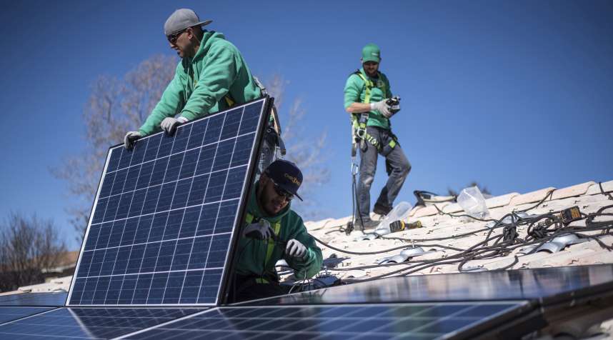 Workers secure solar panels to a rooftop during a SolarCity Corp. residential installation in Albuquerque, New Mexico, on Feb. 8, 2016.