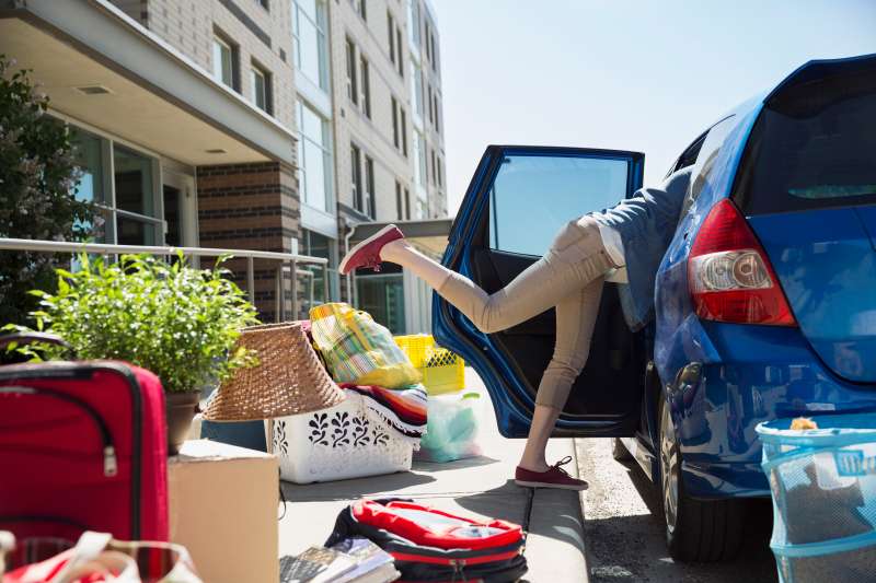 College student reaching in car moving into dorm
