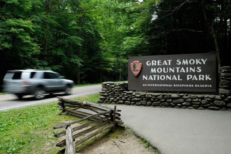 Car truck SUV entering Great Smoky Mountains National Park, with entrance sign, Tennessee.