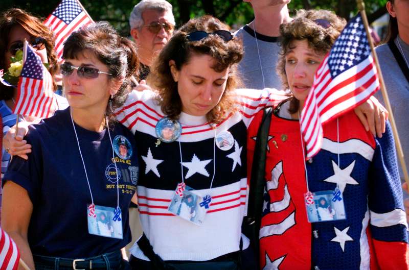 Three women embrace as they march to the  Ground Zero  site of the World Trade Center disaster with family members and friends of victims of the September 11, 2001 attacks on the Trade Center and the Pentagon in New York, September 29, 2002. Several thousand people marched with photographs of their lost loved ones to remember those lost in the attacks.