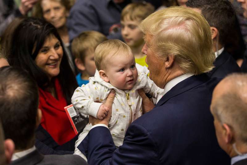 Republican presidential hopeful Donald Trump holds a baby the end of a rally at Great Bay Community College on February 4, 2016 in Portsmouth, New Hampshire.