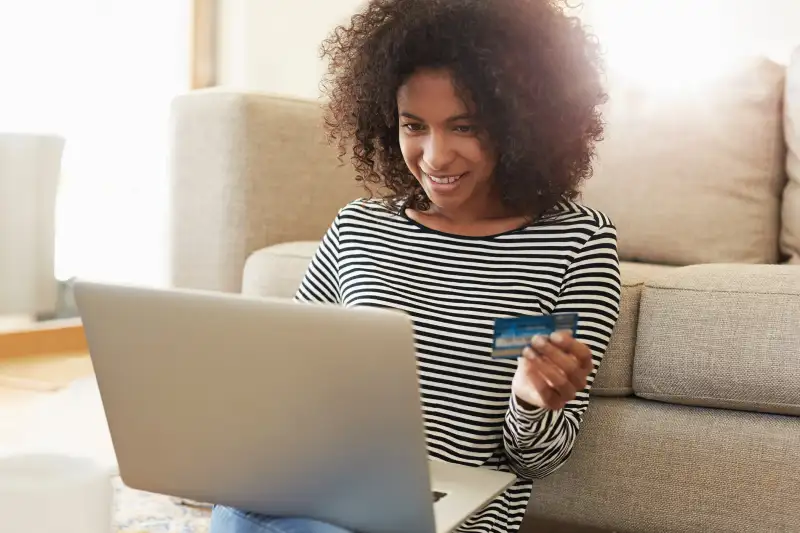 Shot of a young woman using her credit card to make an online payment