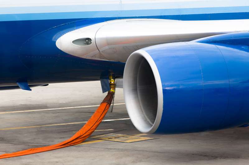 Orange hose ready to refill kerosene gas in to tanks of a jet plane.