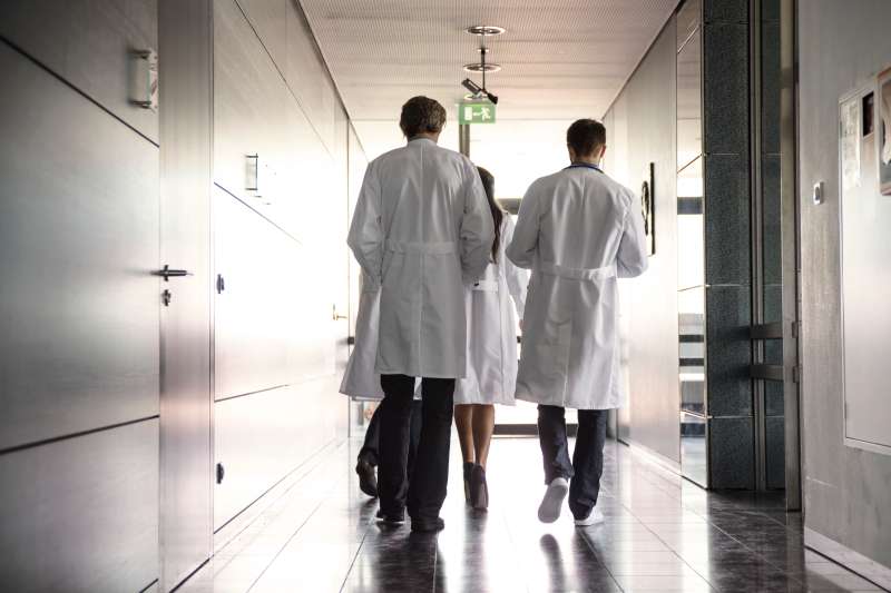 team of doctors walking in hospital hallway