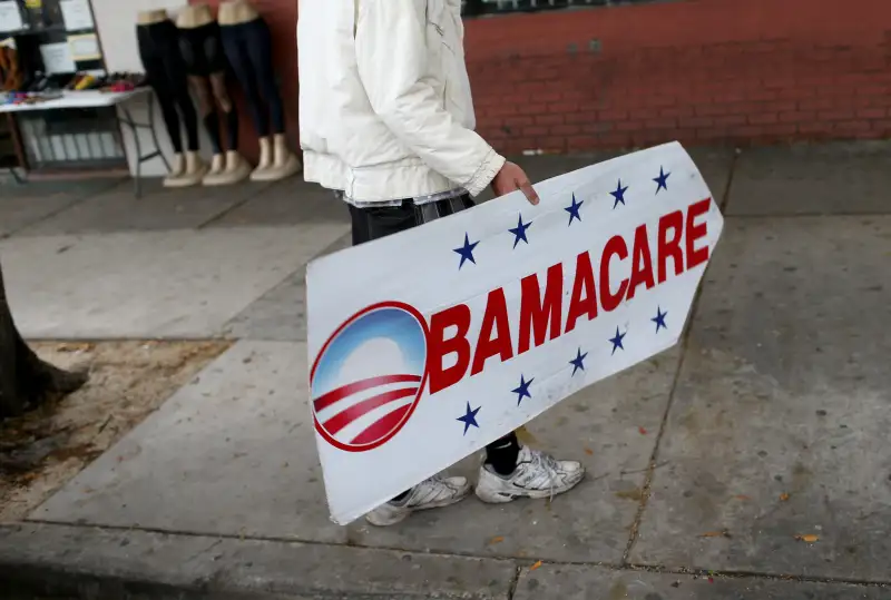 Pedro Rojas holds a sign directing people to an insurance company where they can sign up for the Affordable Care Act, also known as Obamacare, before the February 15th deadline on February 5, 2015 in Miami, Florida.