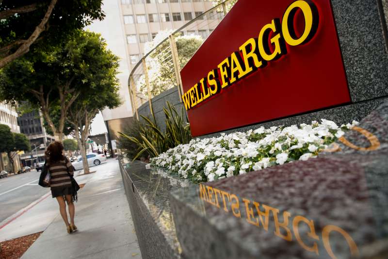 A woman walks past a Wells Fargo &amp; Co. bank branch in Los Angeles, California, U.S., on Tuesday, July 7, 2015.