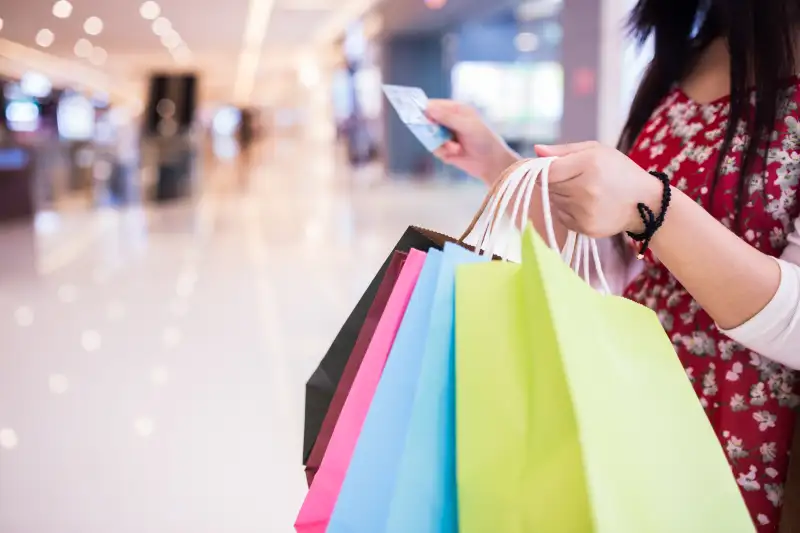 Woman shopping and paying with a debit or credit card