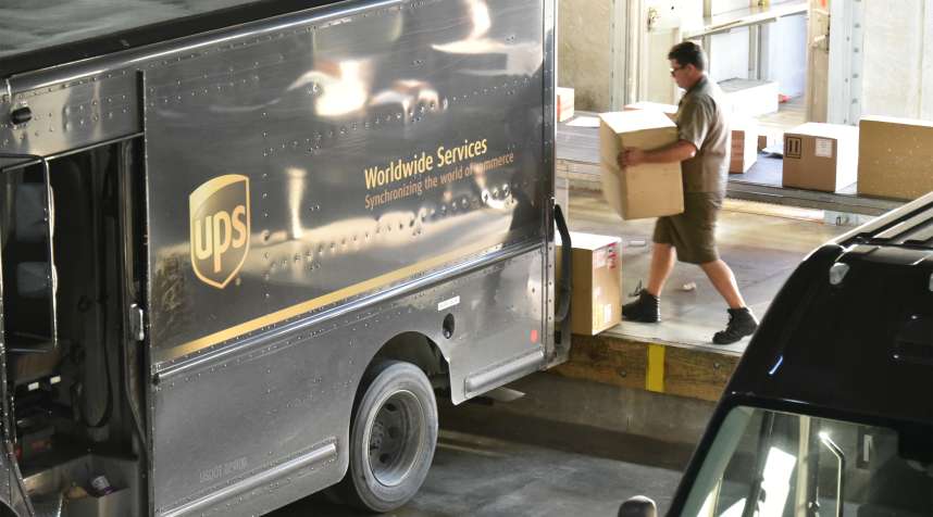 A United Parcel Service Inc. (UPS) driver loads packages onto a delivery truck at the company's Latin America and Caribbean sorting facilities at Miami International Airport in Miami, Florida, U.S., on Friday, Aug. 5, 2016.
