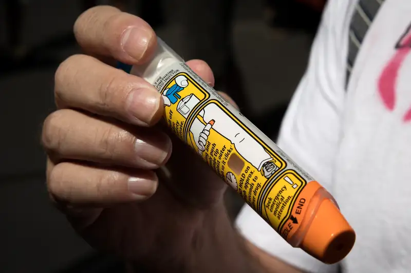 Timothy Lunceford Stevens, who suffers from autoimmune diseases and allergies, holds an EpiPen as he speaks to reporters during a protest against the price of EpiPens, outside the office of hedge fund manager John Paulson, August 30, 2016 in New York City.