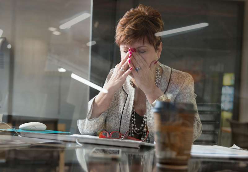 Older Caucasian businesswoman with headache in office
