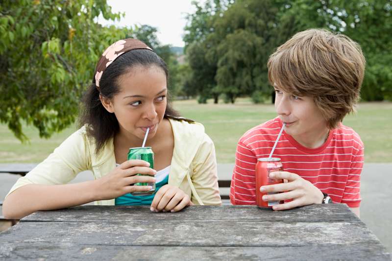 Teenage couple drinking fizzy drinks