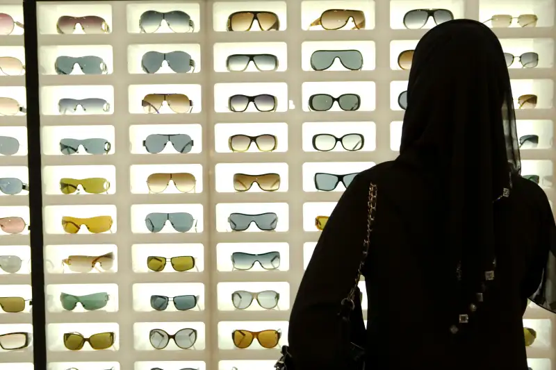 A young Emirati woman shopping for sunglasses.