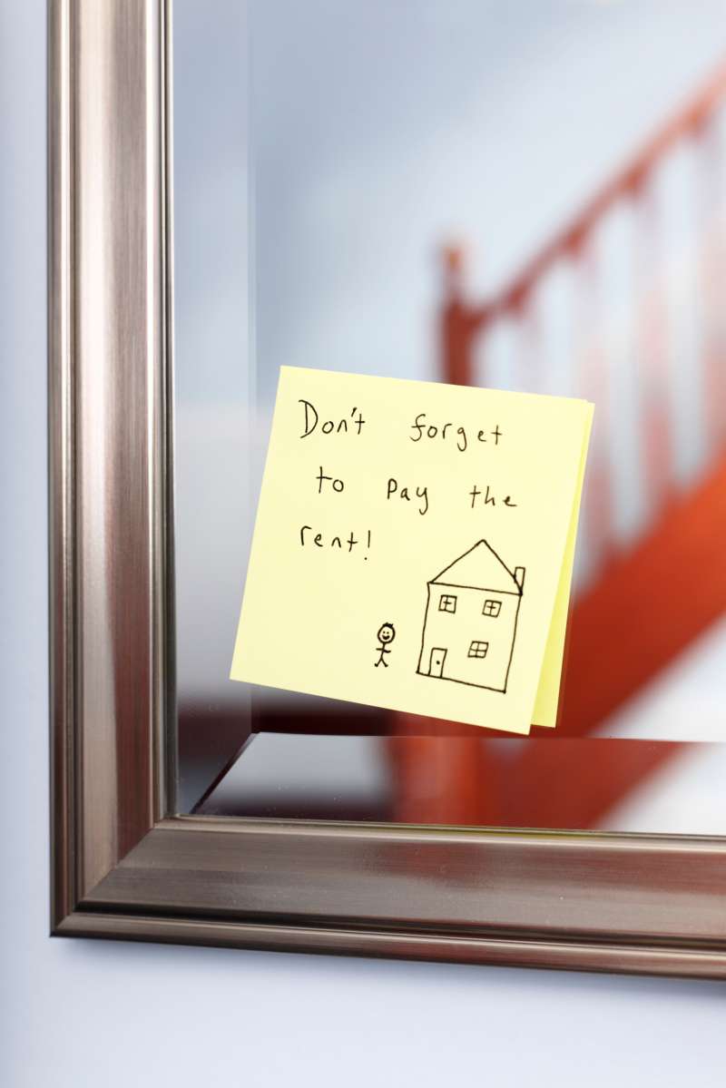 Post-it note with rent reminder on mirror