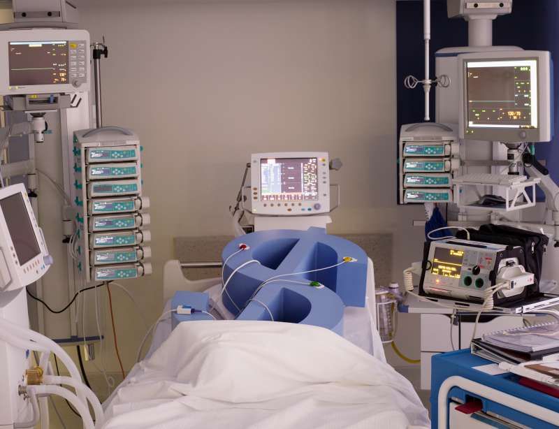 Dollar symbol in hospital bed hooked up to medical equipment