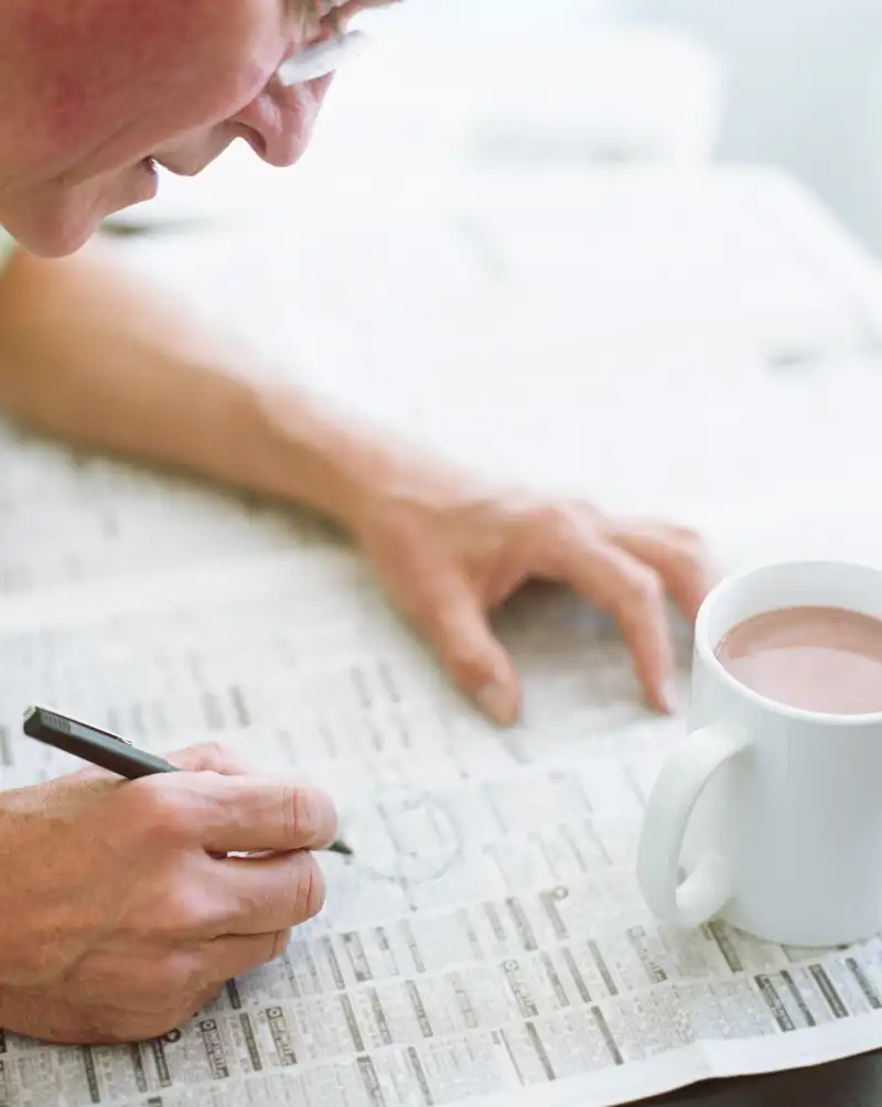 Mature man circling classified ads in newspaper