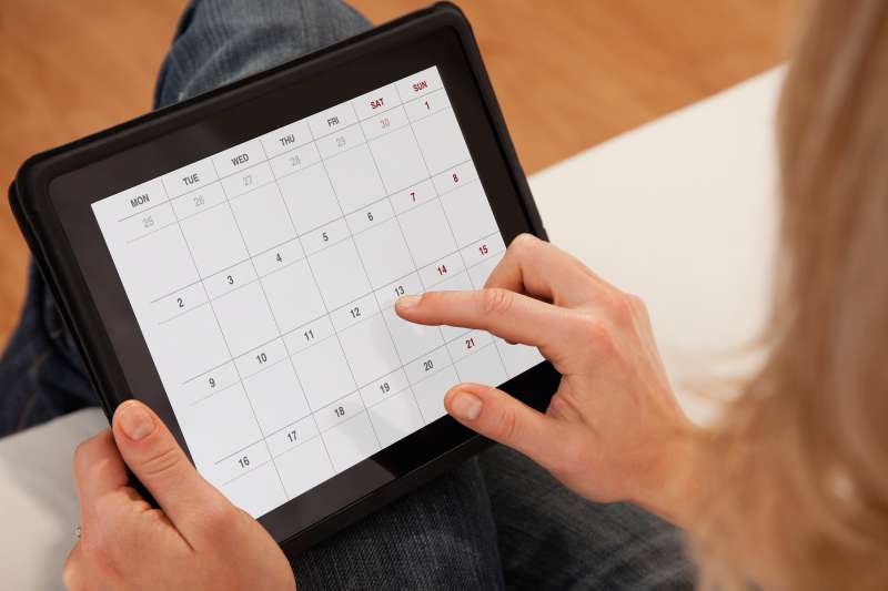 person looking at calendar on tablet screen