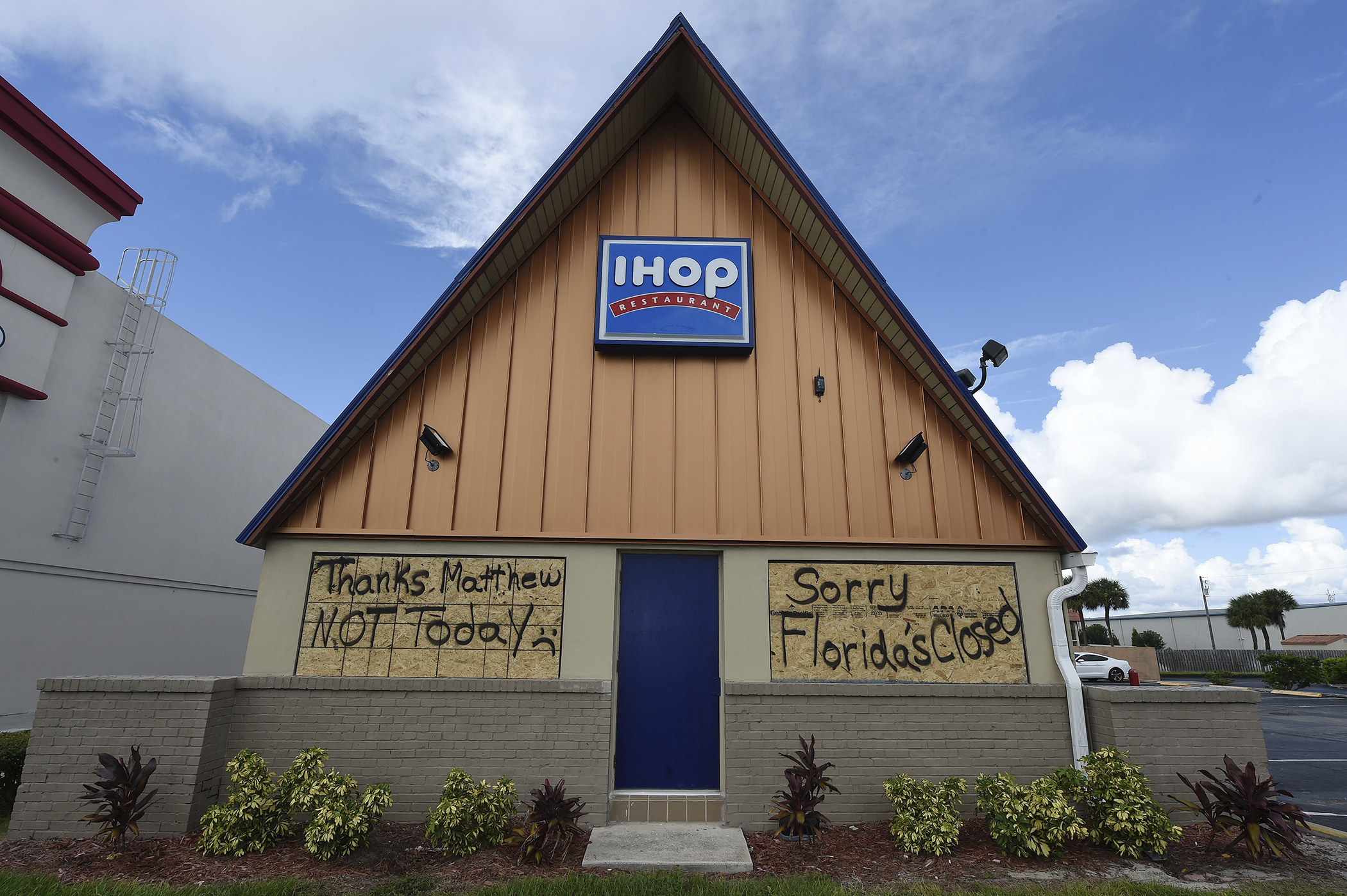 A boarded up IHOP restaurant has messages to Hurricane Matthew written on the plywood as it sits closed ahead of Hurricane Matthew on Cocoa Beach, Florida on October 5, 2016.