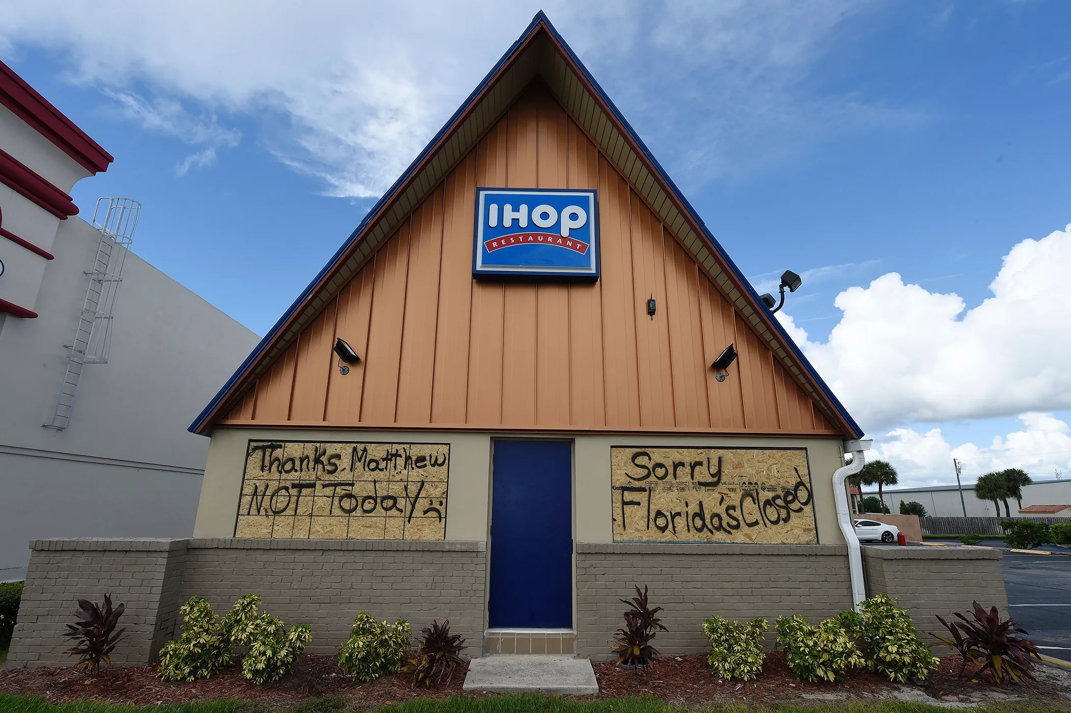 A boarded up IHOP restaurant has messages to Hurricane Matthew written on the plywood as it sits closed ahead of Hurricane Matthew on Cocoa Beach, Florida on October 5, 2016.