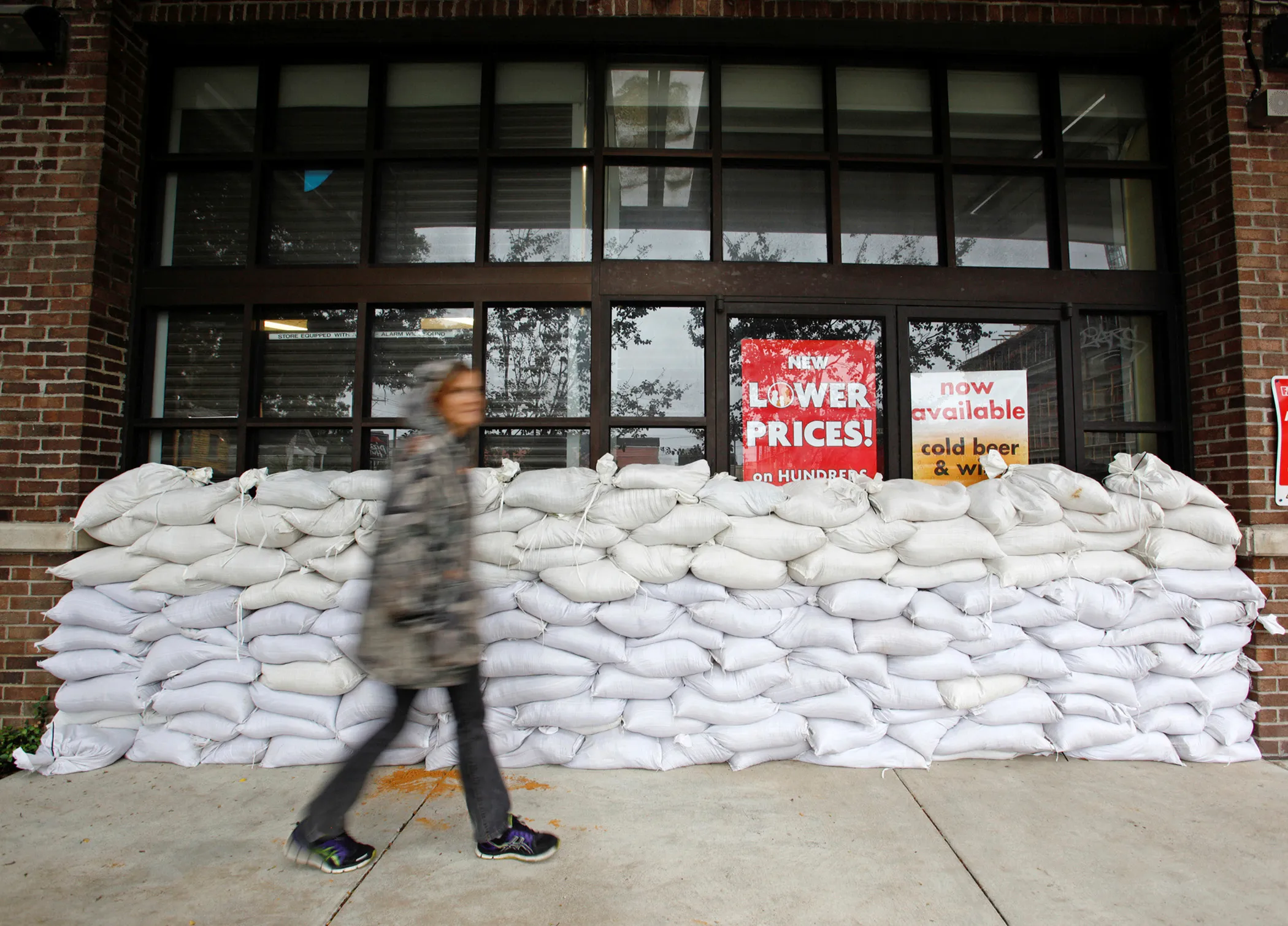 A resident walks past a wall of sandbags protecting a store in one of the city's low-lying areas before the arrival of Hurricane Matthew, in Charleston, South Carolina,  October 7, 2016.