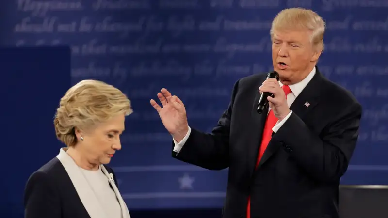 Democratic presidential nominee Hillary Clinton walks past Republican presidential nominee Donald Trump during the second presidential debate at Washington University in St. Louis, Sunday, Oct. 9, 2016.